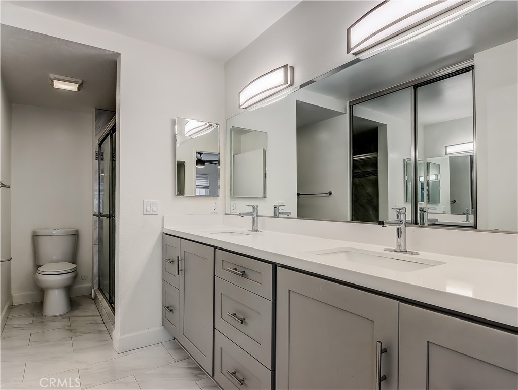 98 Greenfield, Unit 95 Irvine, CA 92614 - Photo 27 of 48 a bathroom with a granite countertop sink mirror and toilet