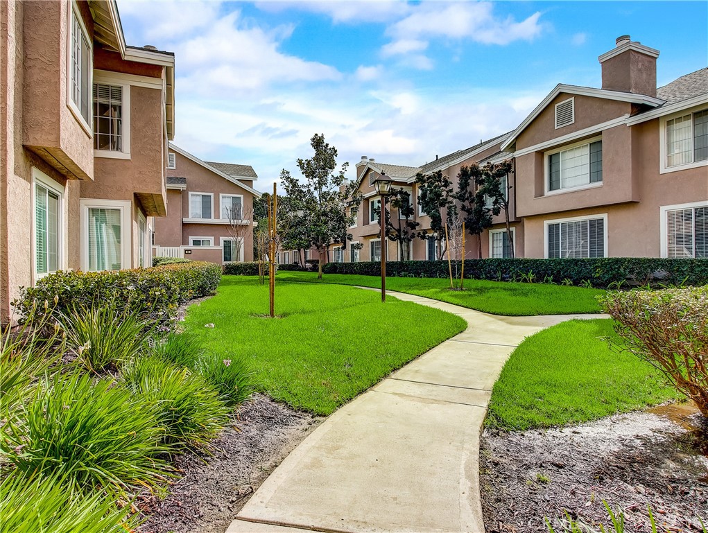 98 Greenfield, Unit 95 Irvine, CA 92614 - Photo 42 of 48 a view of a white house with a big yard and potted plants