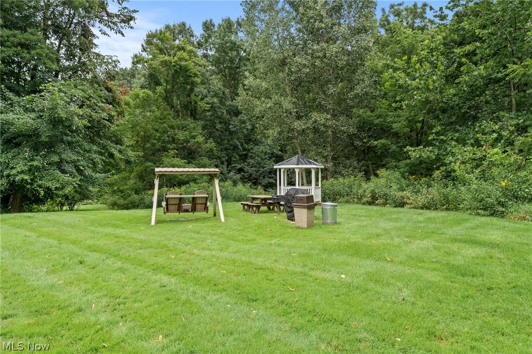 3070 Kent Road, Unit 312D Stow, OH 44224 - Photo 45 of 49 Expansive green lawn featuring a wooden swing set and a white gazebo