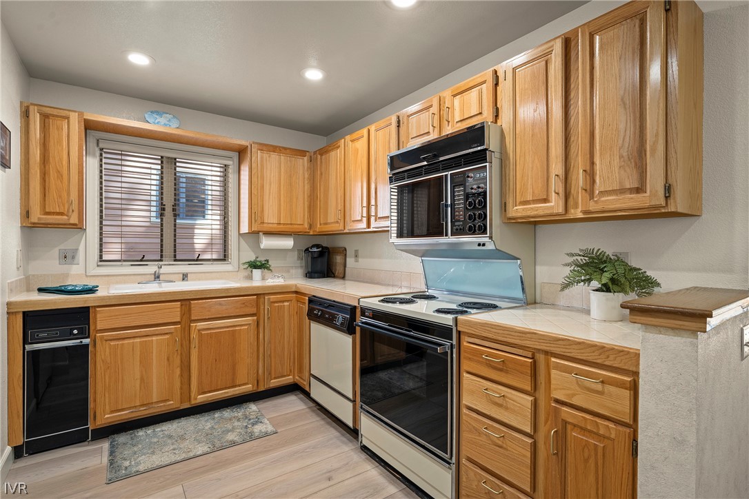 931 Incline Way, Unit 230 Incline Village, NV 89451 - Photo 12 of 24 a kitchen with stainless steel appliances granite countertop wooden cabinets a sink and a stove