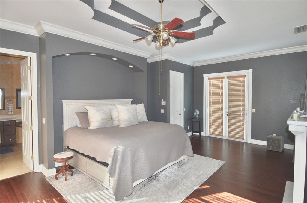 3605 Stabile Road St. James City, FL 33956 - Photo 49 of 95 a bedroom with a large bed and a chandelier