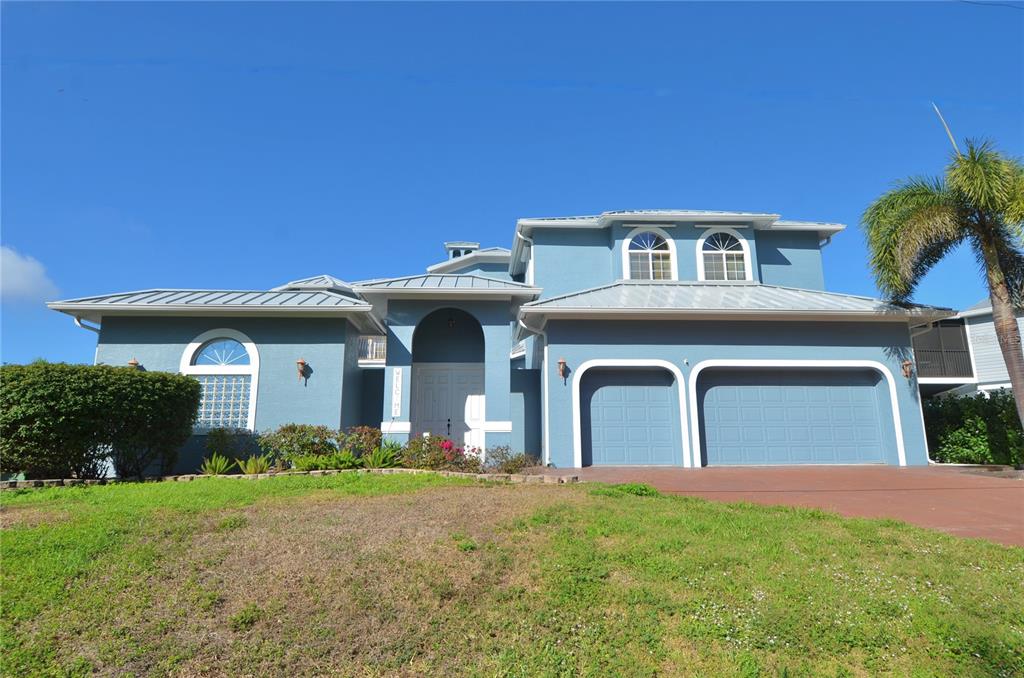 3605 Stabile Road St. James City, FL 33956 - Photo 90 of 95 a front view of a house with a yard and garage