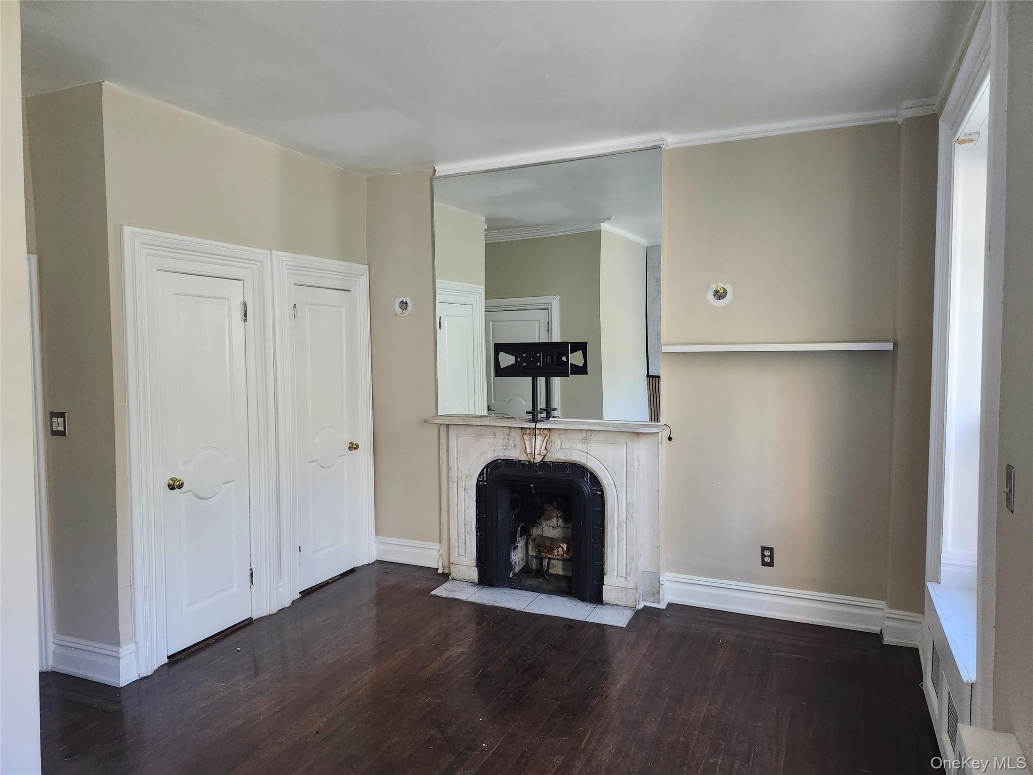 231 East 62nd Street Manhattan, NY 10065 - Photo 13 of 17 Unfurnished BR room featuring dark wood-style flooring, a high end fireplace, and crown molding