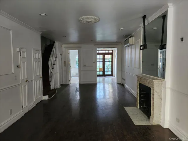 an empty room with wooden floor and a fireplace