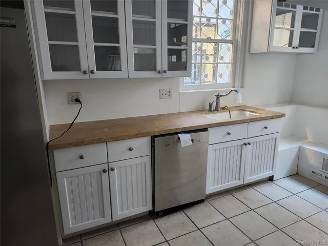 a kitchen with stainless steel appliances granite countertop white cabinets and window