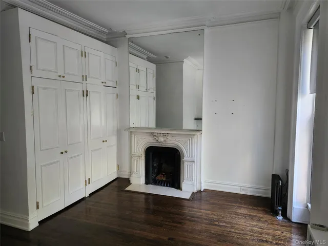 a view of an empty room with a fireplace and a window