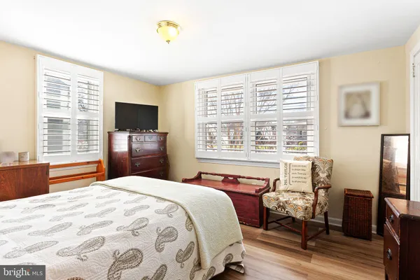 a bedroom with a large bed and a flat tv screen on dresser