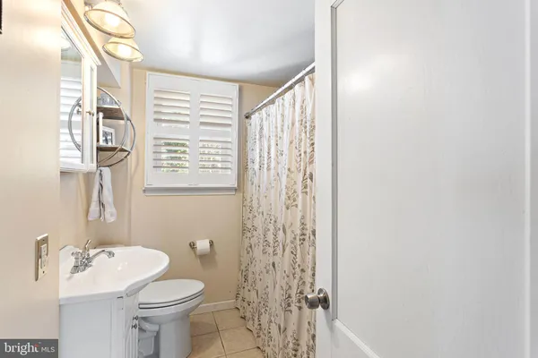 a bathroom with a sink a toilet and shower curtain