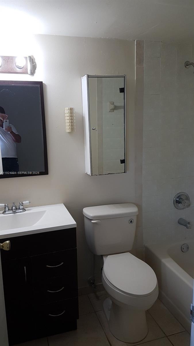 15969 Northwest 64th Avenue, Unit 105 Miami Lakes, FL 33014 - Photo 3 of 9 a bathroom with a toilet sink and mirror