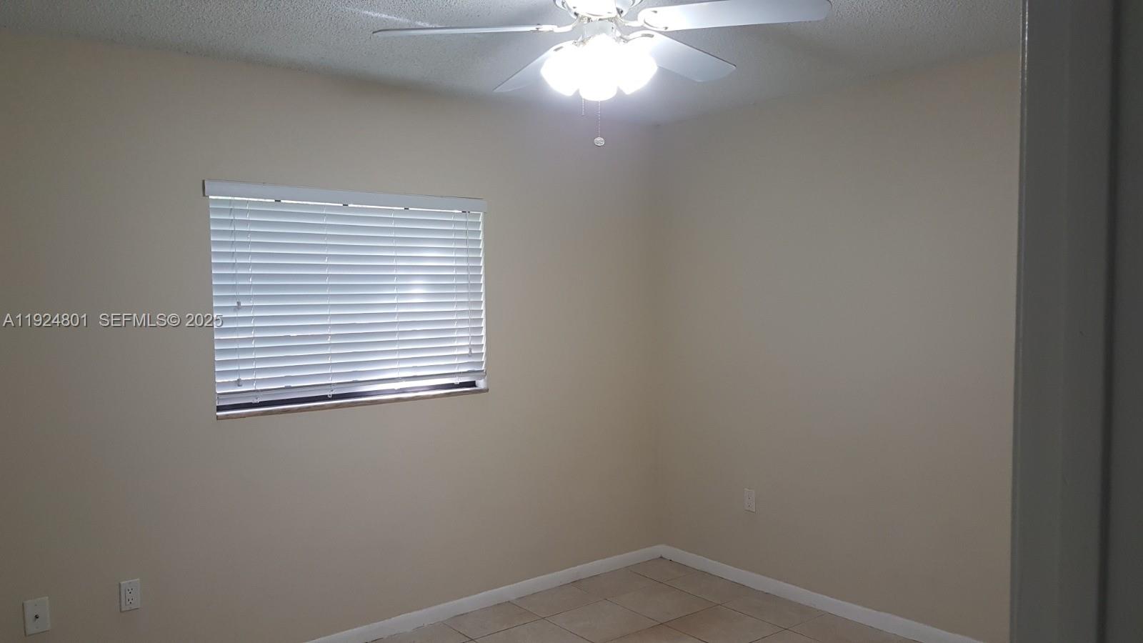 15969 Northwest 64th Avenue, Unit 105 Miami Lakes, FL 33014 - Photo 4 of 9 a view of an empty room with a window