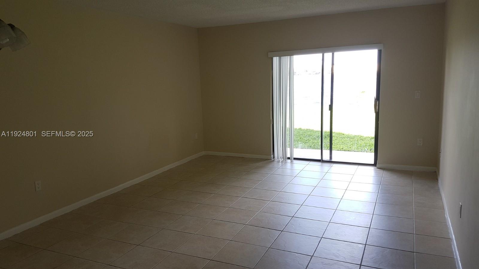 15969 Northwest 64th Avenue, Unit 105 Miami Lakes, FL 33014 - Photo 6 of 9 a view of an empty room with a window