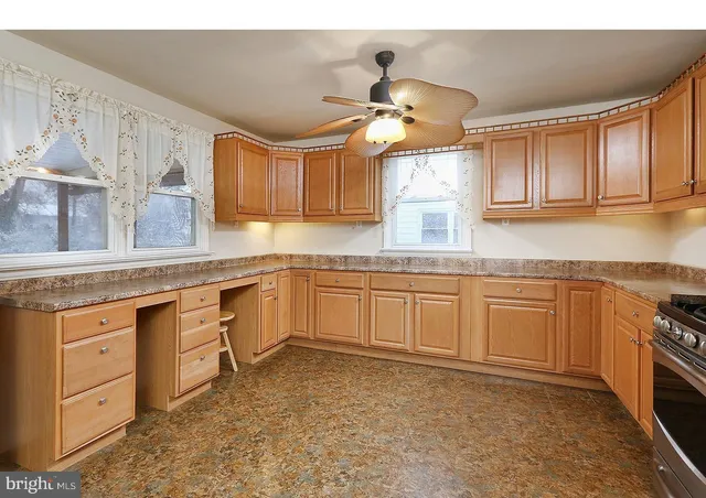 a kitchen with cabinets wooden floor and stainless steel appliances