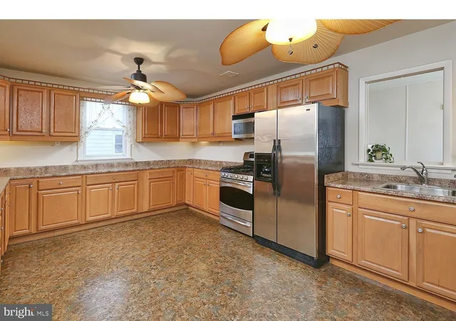 a kitchen with stainless steel appliances granite countertop a sink a stove and refrigerator