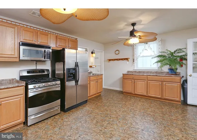 a kitchen with stainless steel appliances a stove a refrigerator and a sink