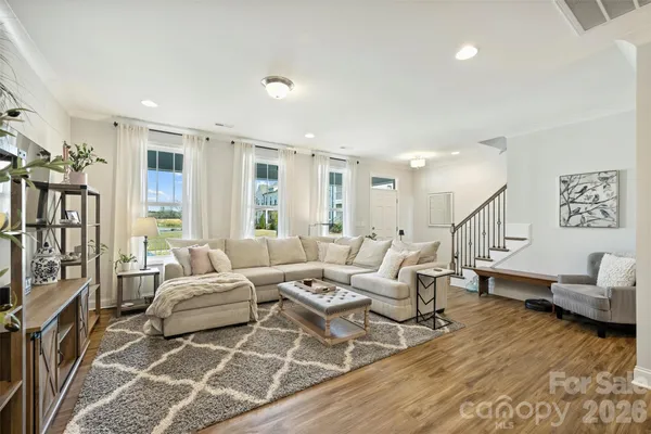 a living room with furniture and a dining table with kitchen view