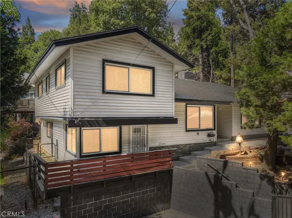 a front view of house along with trees