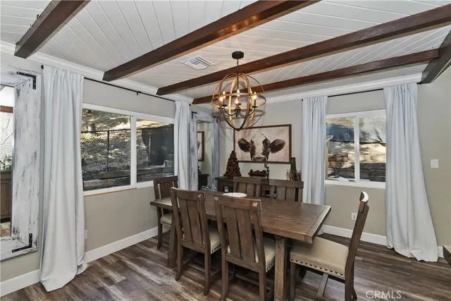 a view of a dining room with furniture a chandelier and wooden floor