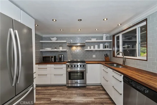 a kitchen with stainless steel appliances granite countertop a stove a sink and a refrigerator