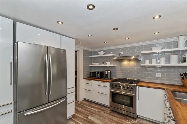 a kitchen with stainless steel appliances a refrigerator sink and stove