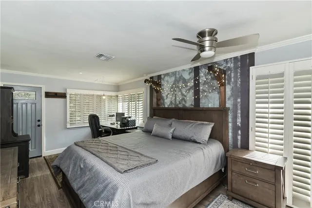 a bedroom with a bed window and a flat screen tv