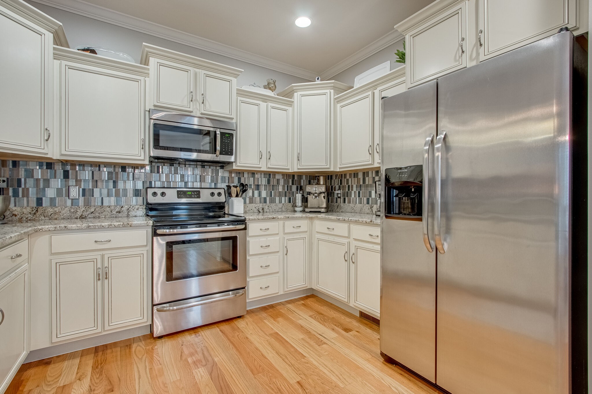 1094 Golf View Way Spring Hill, TN 37174 - Photo 11 of 26 a kitchen with stainless steel appliances white cabinets and wooden floor