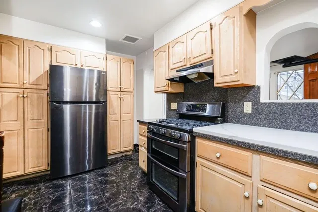a kitchen with stainless steel appliances granite countertop a refrigerator stove and sink