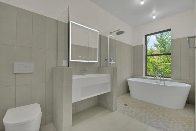 a bathroom with a tub toilet and window