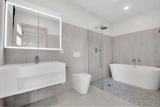 a bathroom with a white tub shower and sink