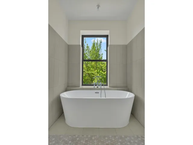 a white bath tub sitting in a bathroom with a sink