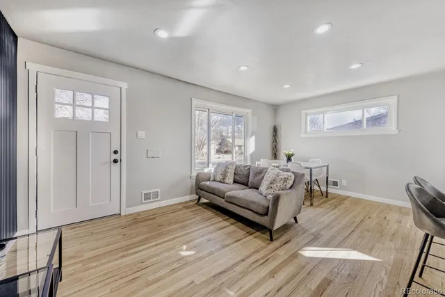 a living room with furniture and a wooden floor