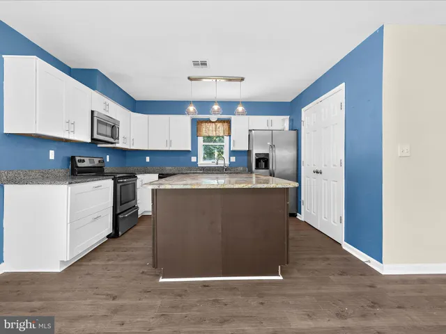 a kitchen with stainless steel appliances granite countertop a stove a sink dishwasher and a refrigerator
