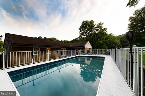 a view of a backyard with large trees and a barn