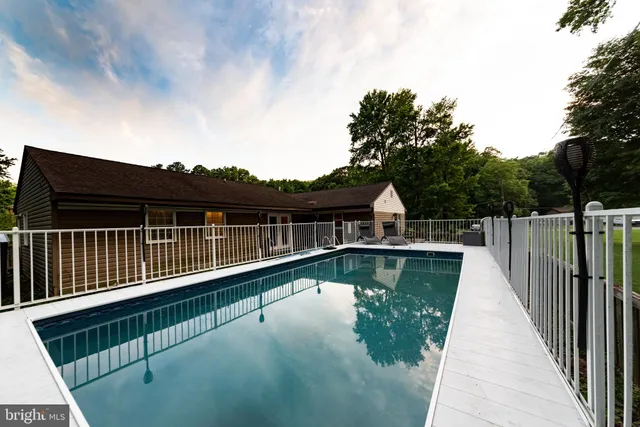 a view of a backyard with large trees and a barn