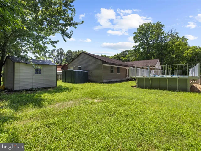 a backyard of a house with plants and large tree
