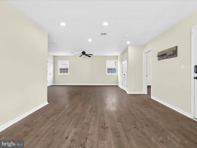 a view of a livingroom with a chandelier and wooden floor