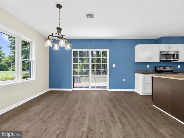 a kitchen with stainless steel appliances granite countertop a refrigerator a sink a stove a microwave and wooden cabinets