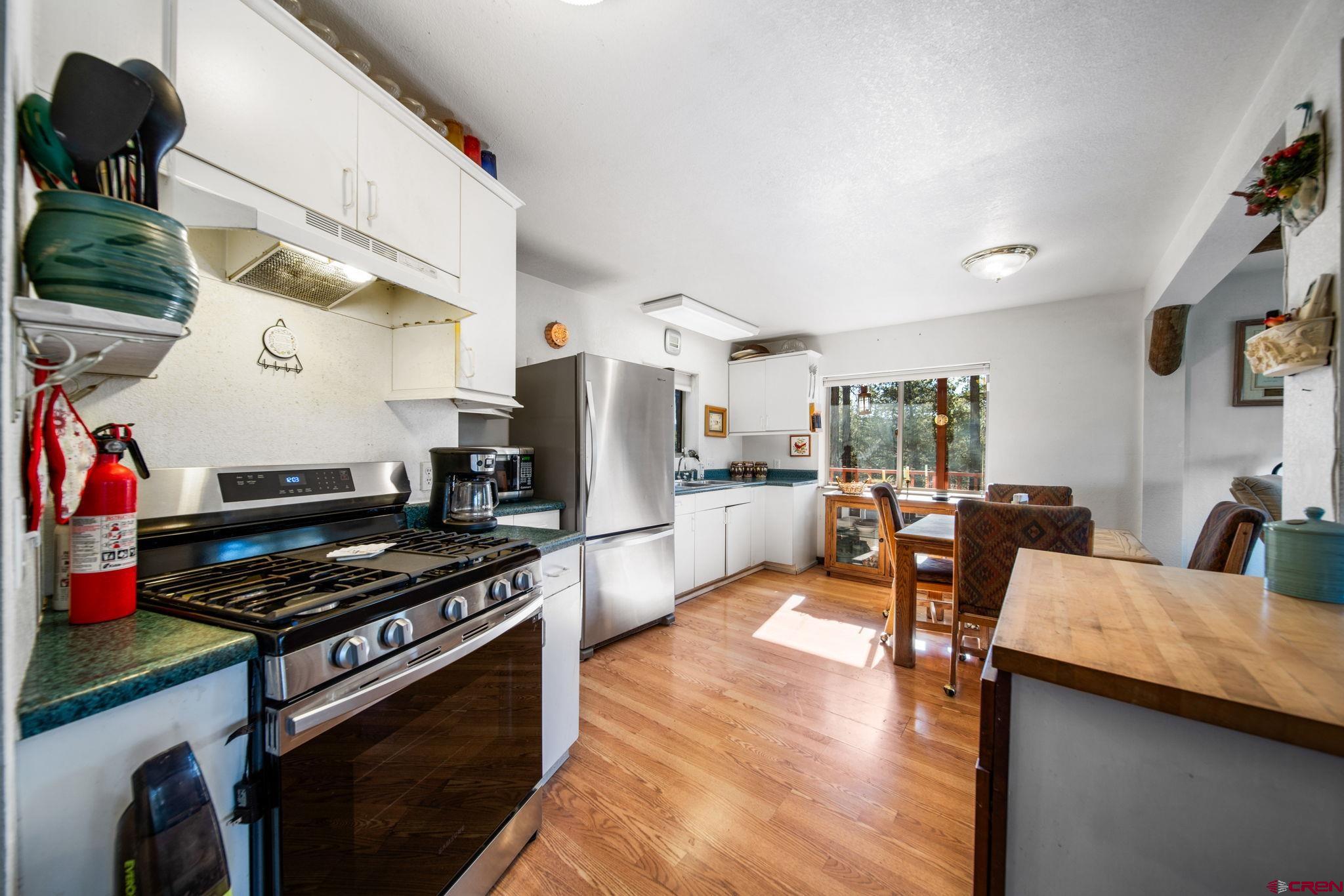 900 Spring Road Durango, CO 81303 - Photo 8 of 33 a kitchen with stainless steel appliances kitchen island granite countertop a stove and a refrigerator