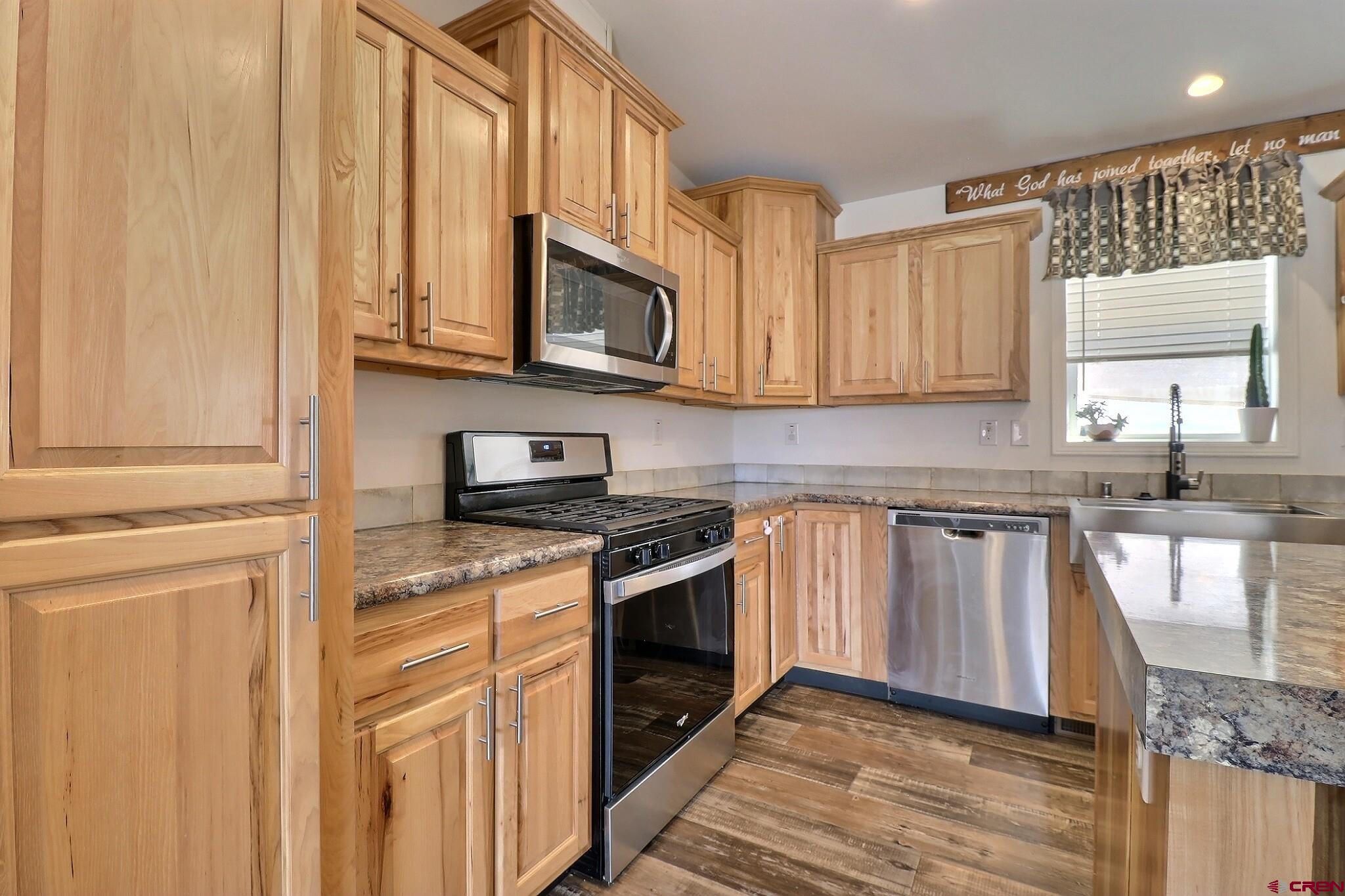 808 1525th Road Delta, CO 81416 - Photo 11 of 43 a kitchen with stainless steel appliances granite countertop a stove a sink and a microwave