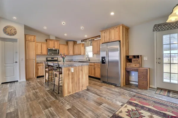 a kitchen with granite countertop a refrigerator and a stove top oven