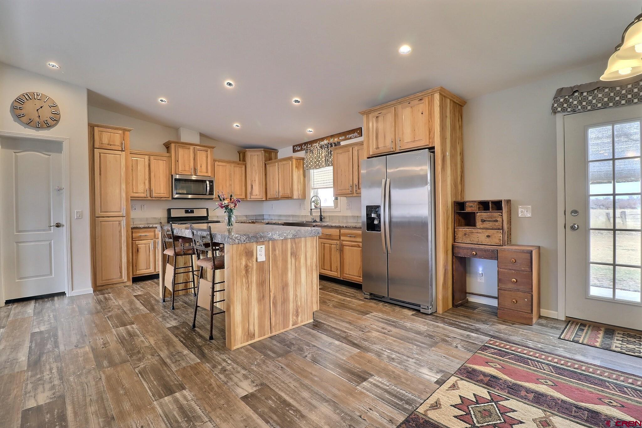 808 1525th Road Delta, CO 81416 - Photo 12 of 43 a kitchen with granite countertop a refrigerator and a stove top oven