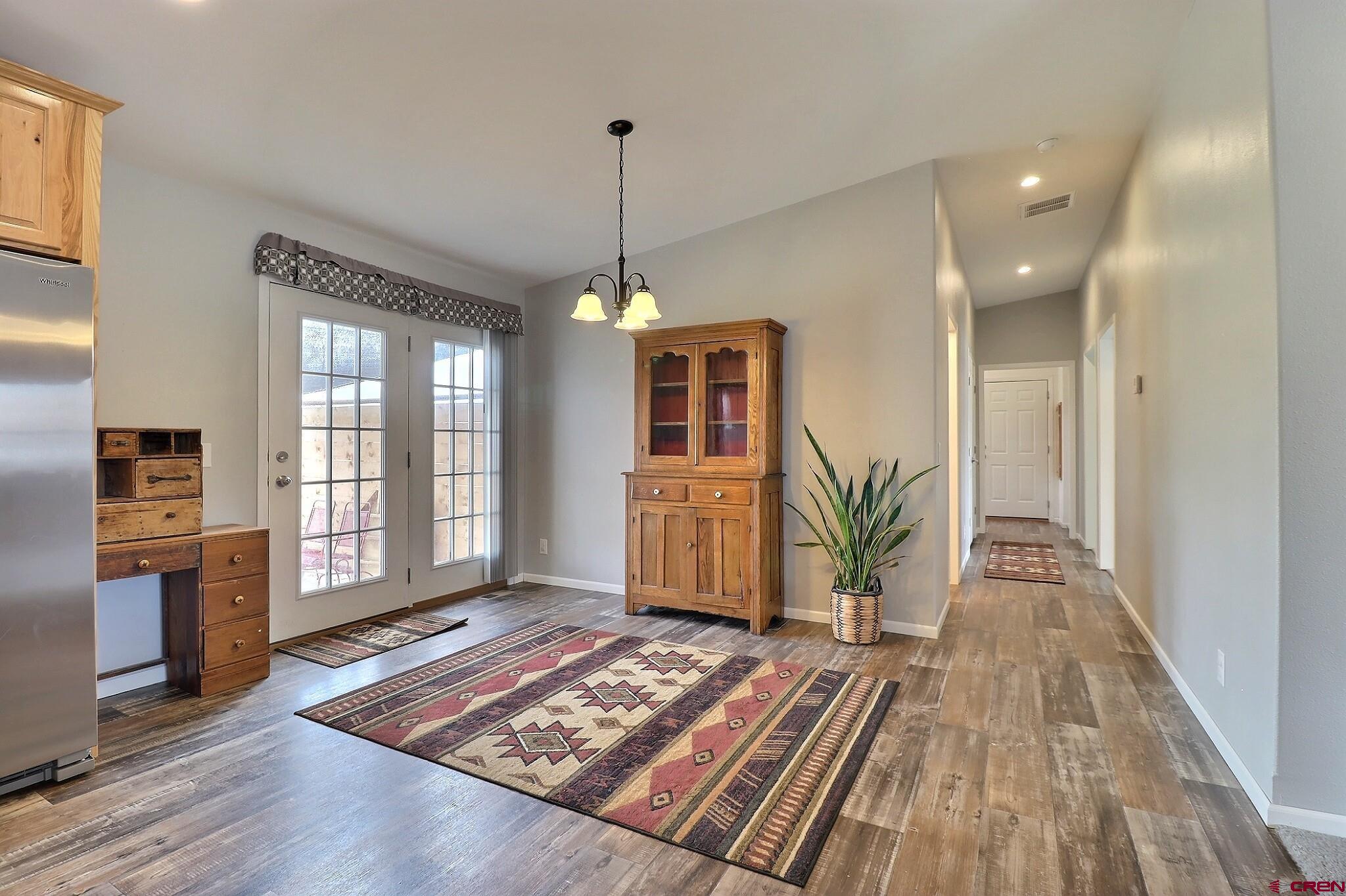 808 1525th Road Delta, CO 81416 - Photo 15 of 43 a view of a hallway with wooden floor windows a chandelier and a living room