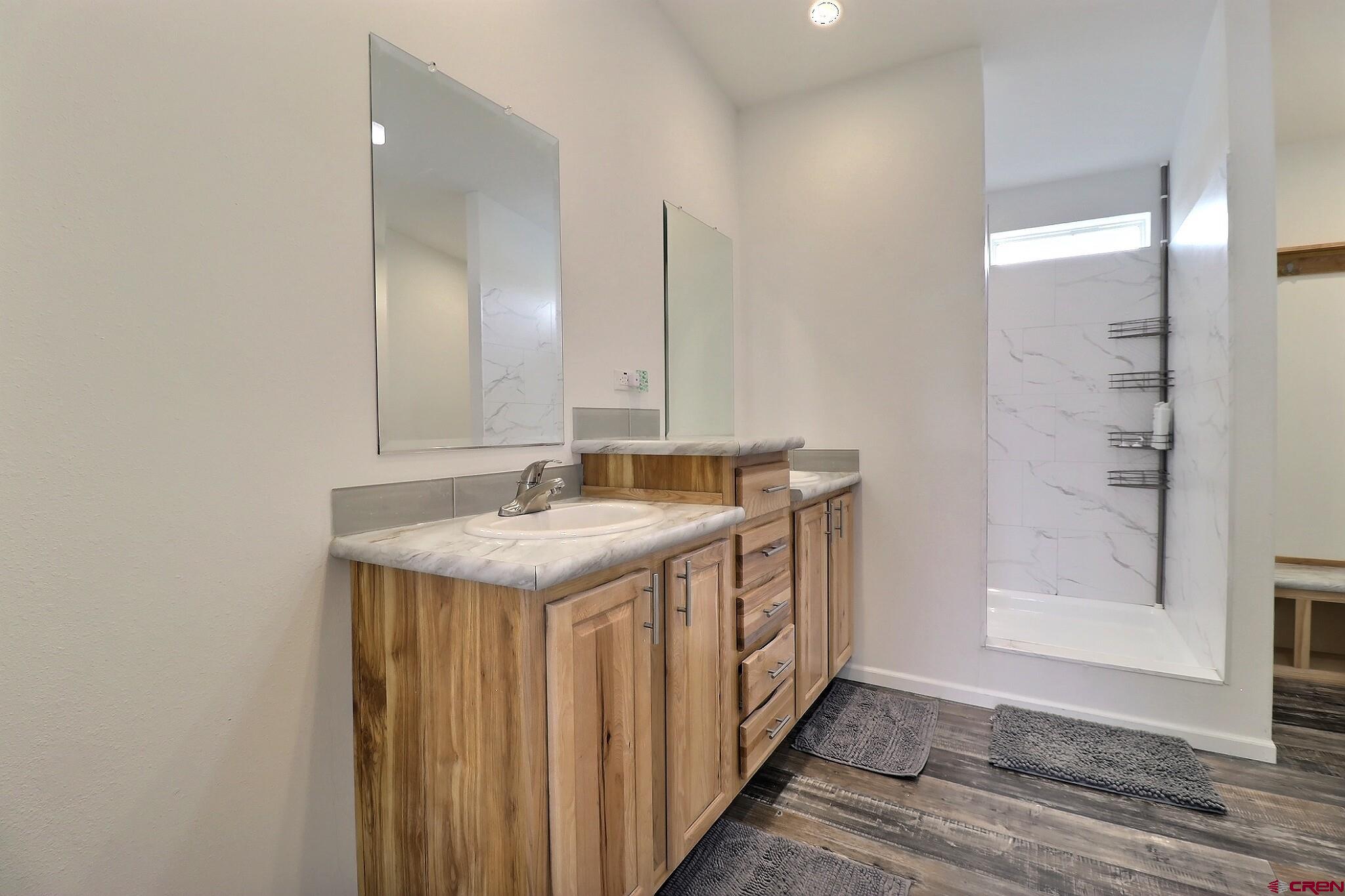 808 1525th Road Delta, CO 81416 - Photo 26 of 43 a bathroom with a granite countertop sink a mirror and a shower