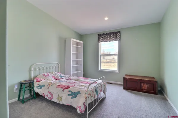 a spacious bedroom with a bed and a window