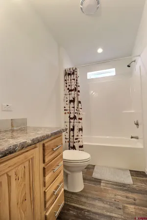 a bathroom with a granite countertop sink a toilet and bathtub