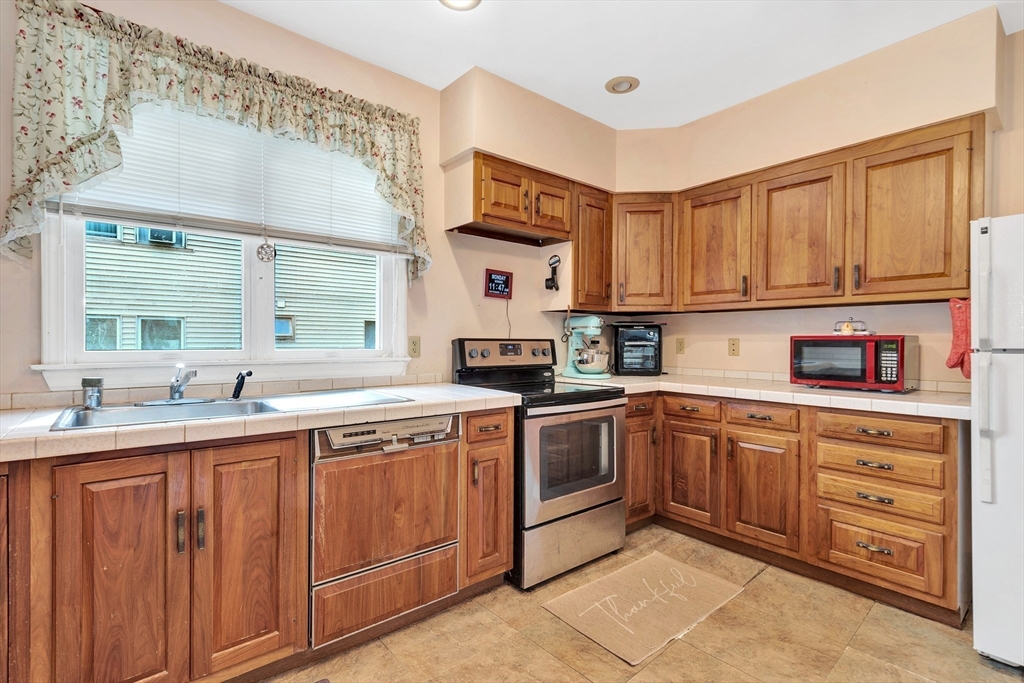 72 Hillside Avenue Lynn, MA 01902 - Photo 11 of 36 a kitchen with a sink stove and cabinets