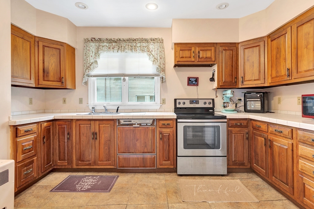 72 Hillside Avenue Lynn, MA 01902 - Photo 12 of 36 a kitchen with stainless steel appliances granite countertop a stove a sink and a microwave