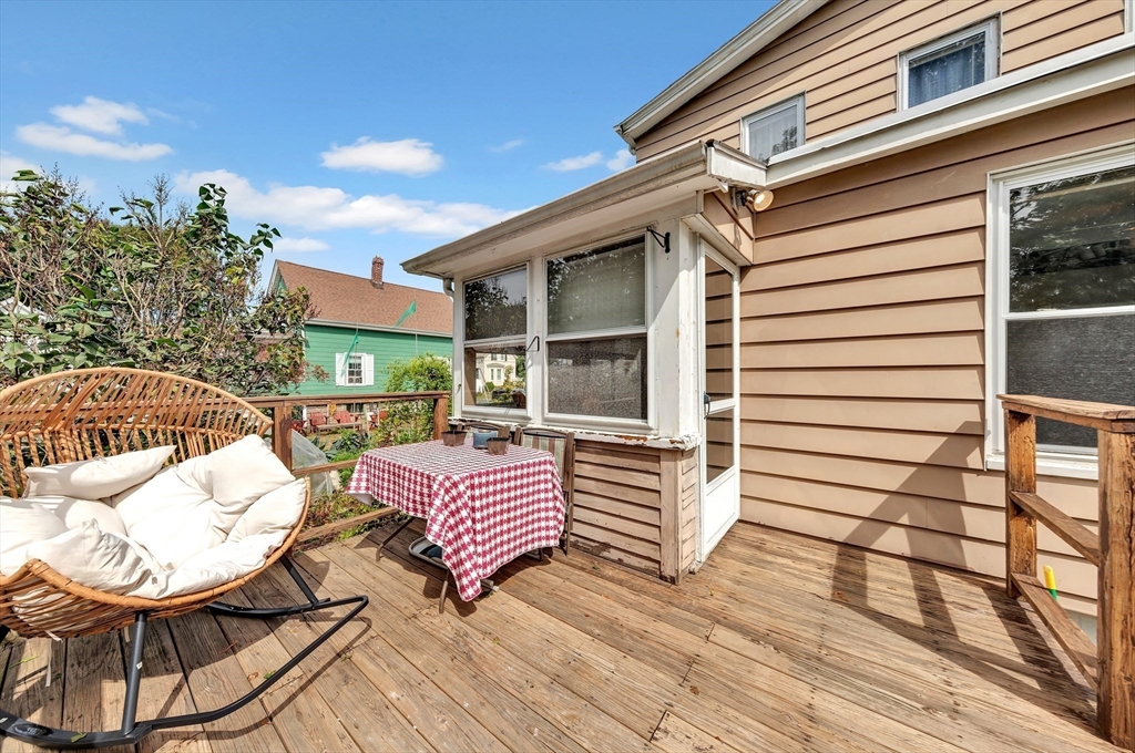 72 Hillside Avenue Lynn, MA 01902 - Photo 28 of 36 a view of a patio with chair and table and chairs with wooden floor and fence