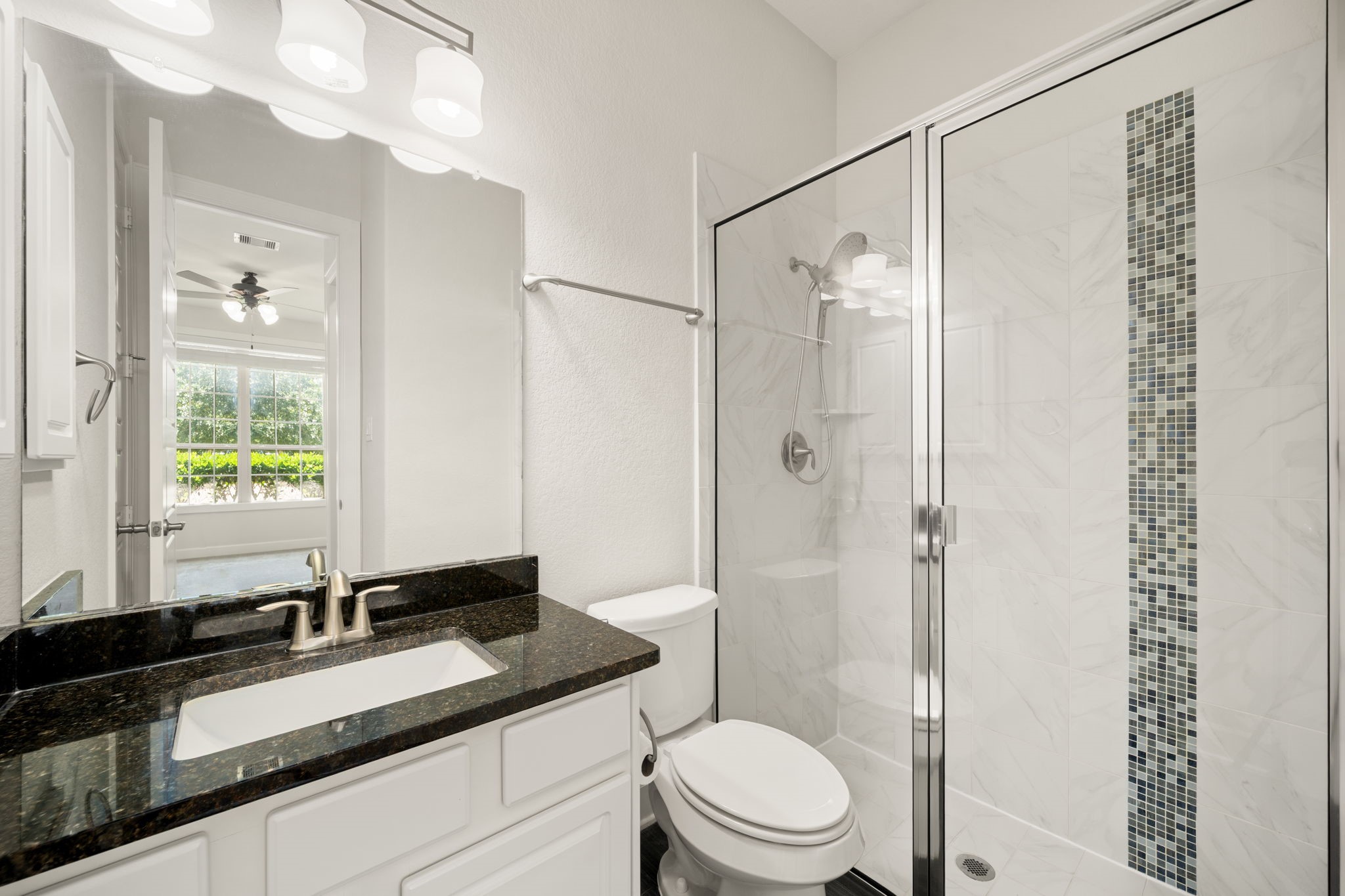 3622 Sage Hollow Drive Spring, TX 77386 - Photo 24 of 46 The adjacent first-floor guest bathroom features an updated single vanity with a dark granite countertop and a mud-set glass shower conversion finished with a premium vertical accent tile band.