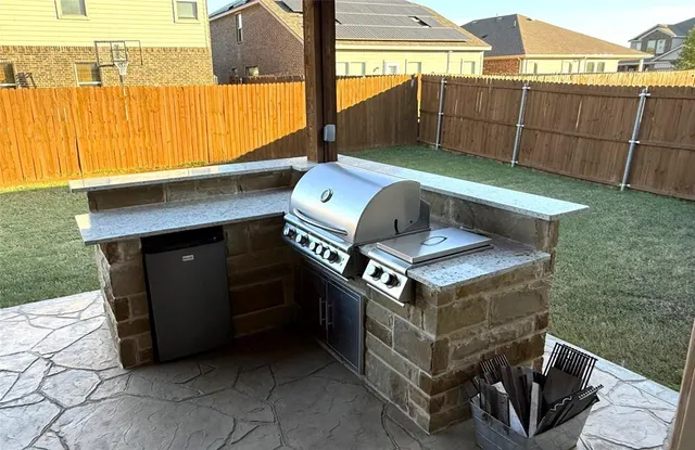 a view of a chairs and table in the back yard