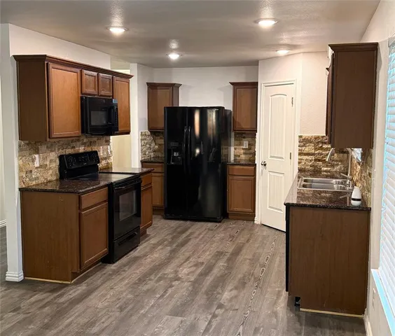 a kitchen with stainless steel appliances granite countertop a refrigerator stove and oven